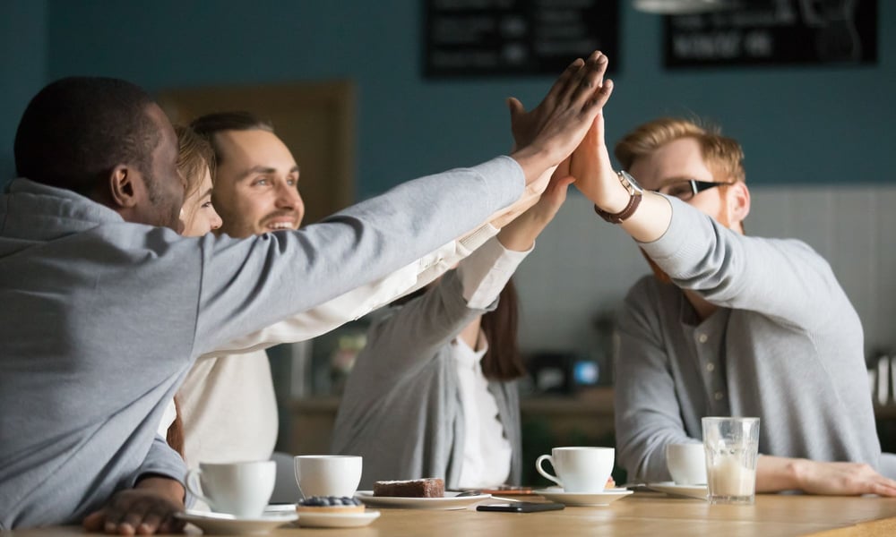 Motivierte Mitarbeiter feiern zusammen